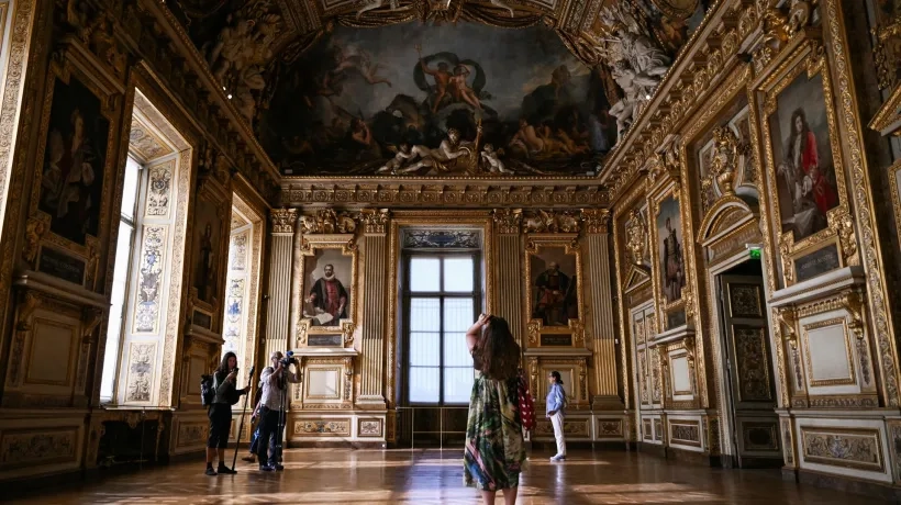 Un grupo de personas recorre la Galería Apolo del Museo del Louvre.