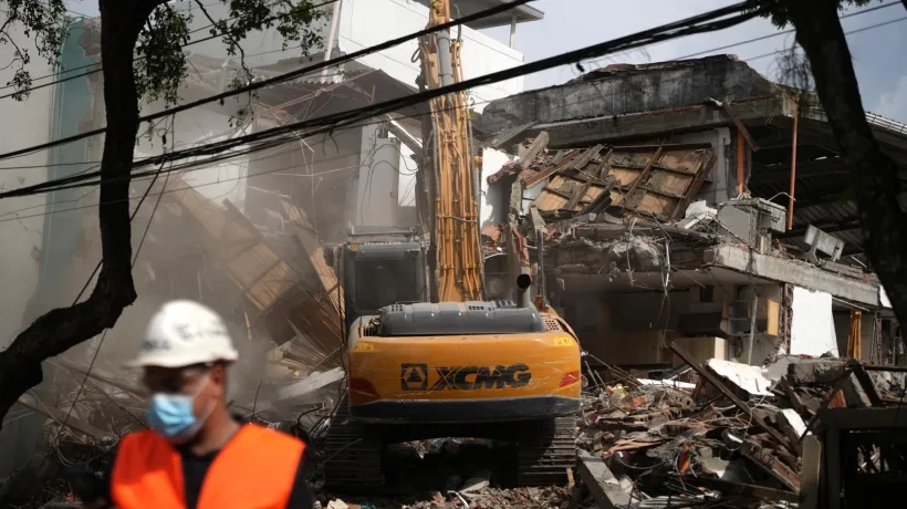 Una retroexcavadora demoliendo un edificio afectado por el terremoto del pasado 10 de agosto, en Cali.