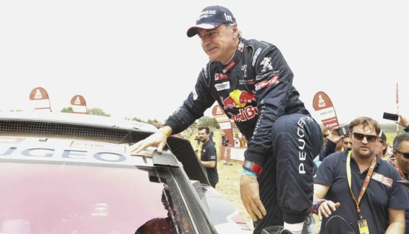 Carlos Saiz sube al techo de su vehículo para festejar su triunfo. 