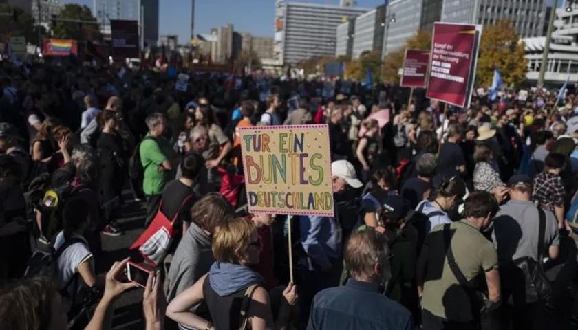 Un manifestante muestra un cartel que dice 'Por una Alemania colorida' (C) en una manifestación titulada '#indivisible - solidaridad en lugar de exclusión' en Berlín, Alemania.