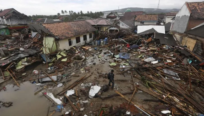 Los residentes locales caminan entre los escombros después de que un tsunami golpeó el Estrecho de Sunda en Sumur, Banten