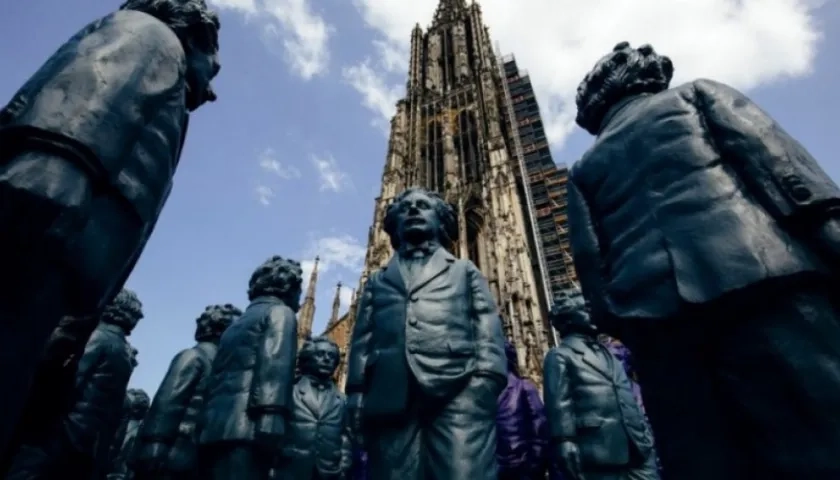 Presentan al físico con semblante pensativo y con una mano en el bolsillo del pantalón, como si fuera un paseante más de la ciudad.