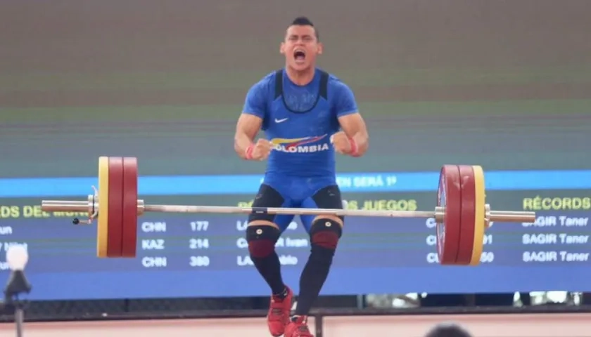 El pesista colombiano Hugo Montes celebra el levantamiento con el que ganó la medalla de oro.