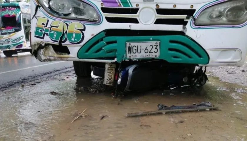 La moto quedó debajo del bus.