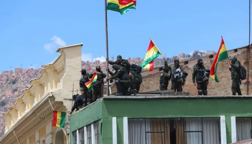 Policías de La Paz se manifiestan con banderas bolivianas luego de replegarse este sábado a una unidad de esa fuerza cercana a la plaza Murillo.
