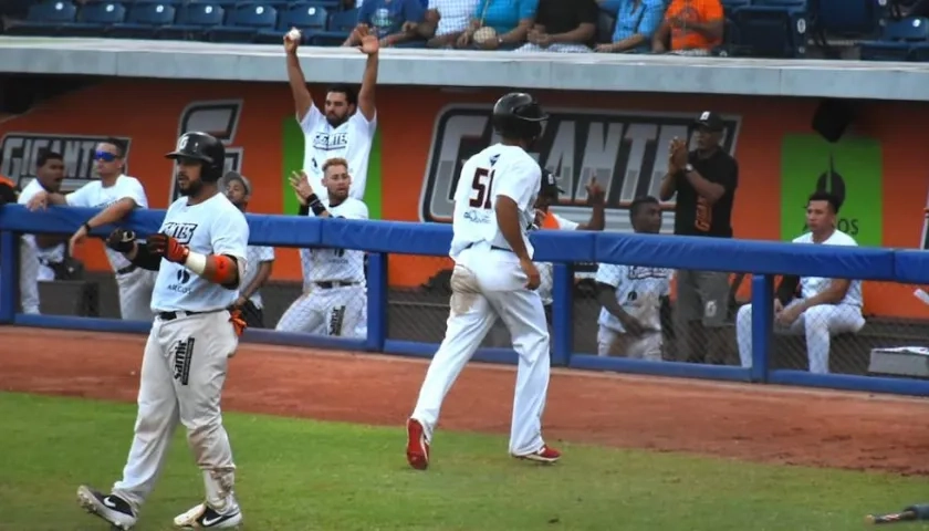 Jugadores de Gigantes celebran un batazo.
