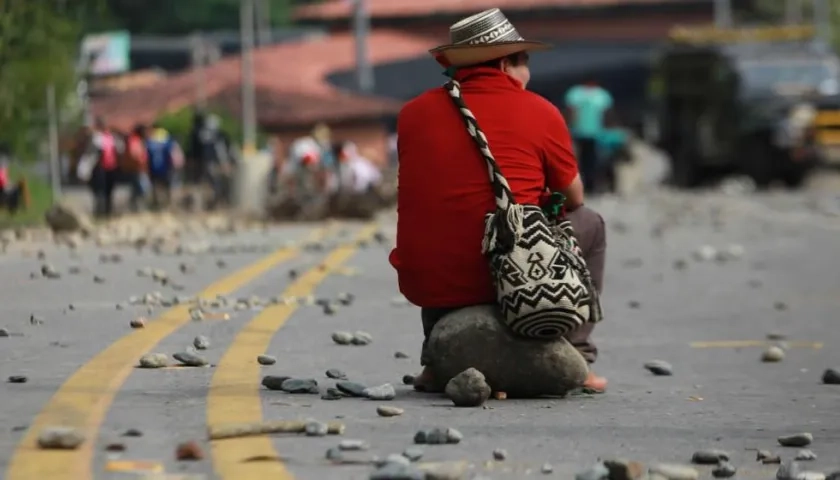 Indígena espera sobre una roca durante el bloqueo de la vía Panamericana en el municipio de Caldono, Cauca