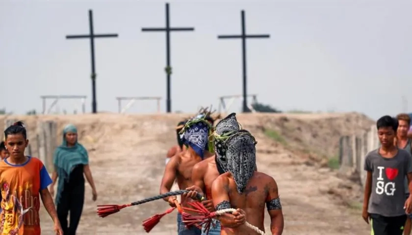 Penitentes con máscaras participan en el Viernes Santo en la aldea de San Juan, San Fernando, Pampanga, Filipinas.