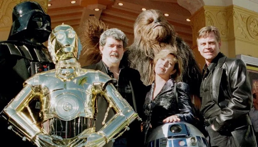 George Lucas con algunos de los personajes de Stars Wars y el actor Mark Hamill.