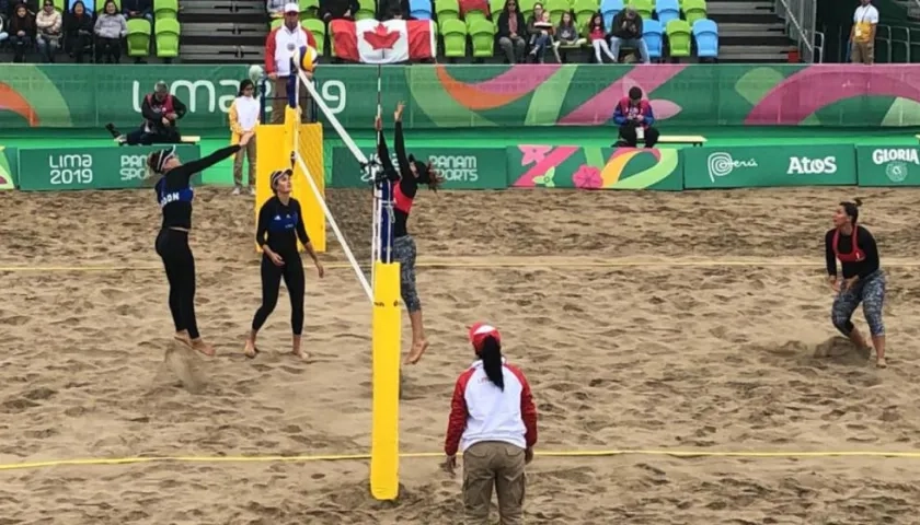 Las jugadoras de Estados Unidos rematan en la red ante la defensa de Colombia. 