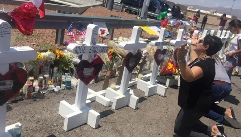Una señora ora junto a las cruces que fueron colocadas frente a la tienda Walmart en El Paso, Texas, lugar donde ocurrió una masacre.