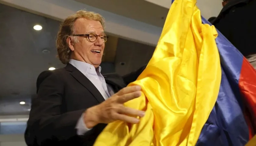 El violinista de Países Bajos André Rieu enarbola este lunes una bandera colombiana tras arribar al Aeropuerto Internacional El Dorado, en Bogotá (Colombia).