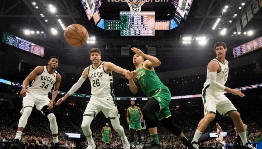Jugadores de los Bucks observan a la pelota salir por la línea de fondo. 