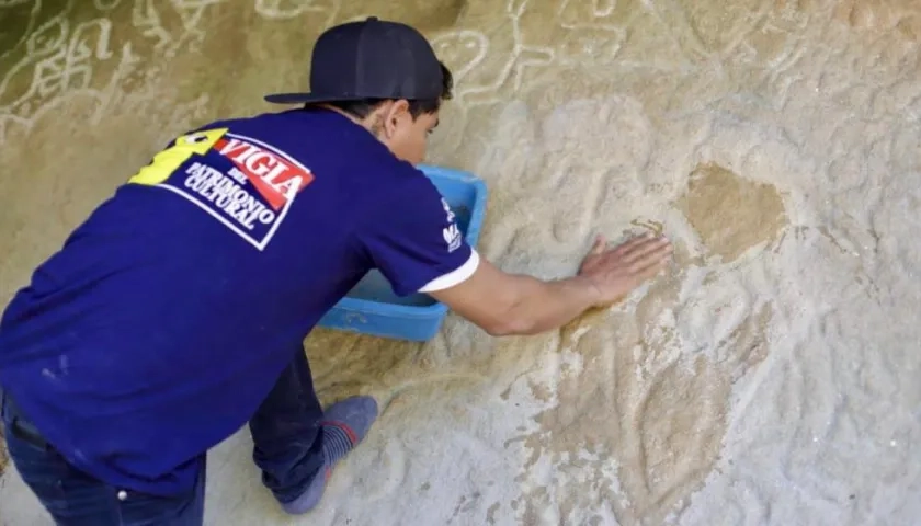 Uno de los 7 Vigías del Patrimonio restaurando la figura.