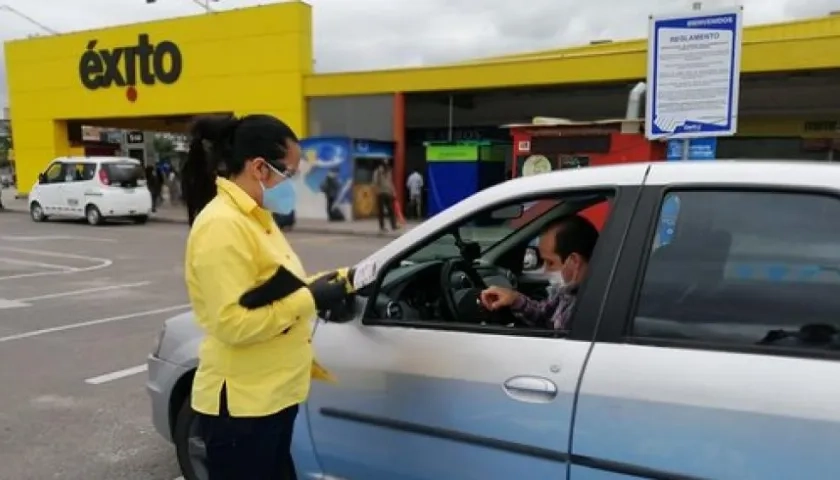 Empleada de Éxito atendiendo a cliente en uno de los puntos de 'Compra y recoge'.