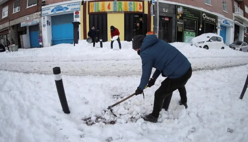 Ciudadanos despejan de nieve las calles de los alrededores del Hospital Gregorio Marañón de Madrid tras el paso de la borrasca Filomena.