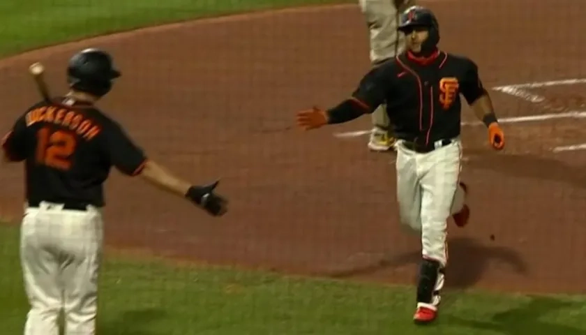 Donovan Solano anota tras su cuadrangular. 