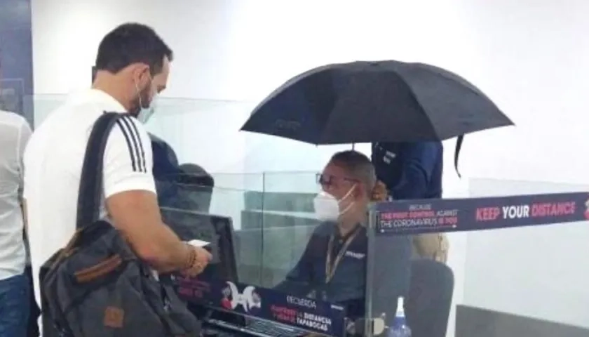 Funcionarios de Migración Colombia protegiéndose de las goteras dentro del mismo aeropuerto.