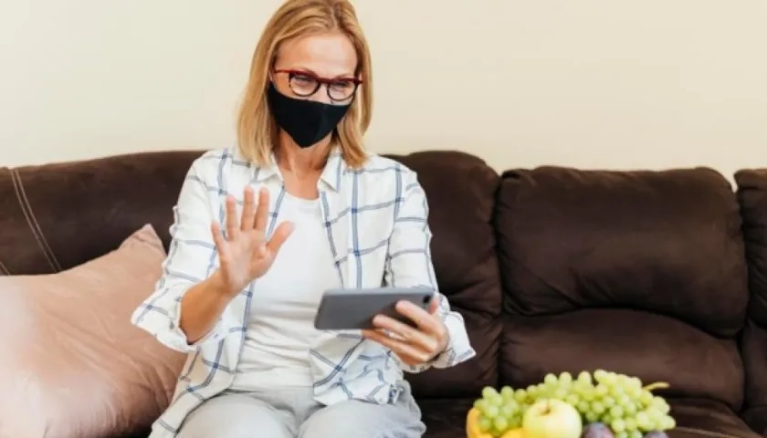 Una mujer habla por su teléfono celular dentro de su casa durante la cuarentena por la pandemia de Covid-19.