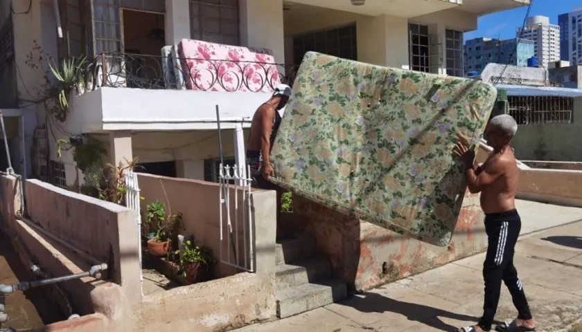   Varias personas sacan a la calle sus pertenencias tras el paso del huracán Ian en La Habana.