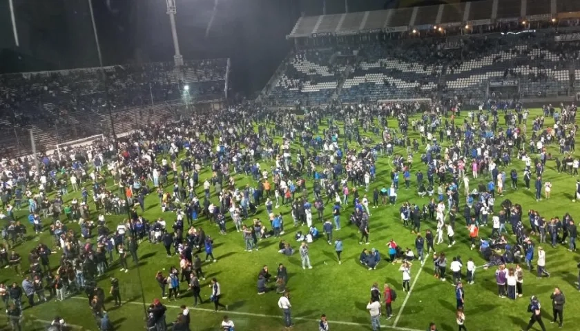 Hinchas en el terreno de juego de la cancha de Gimnasia y Esgrima de La Plata.