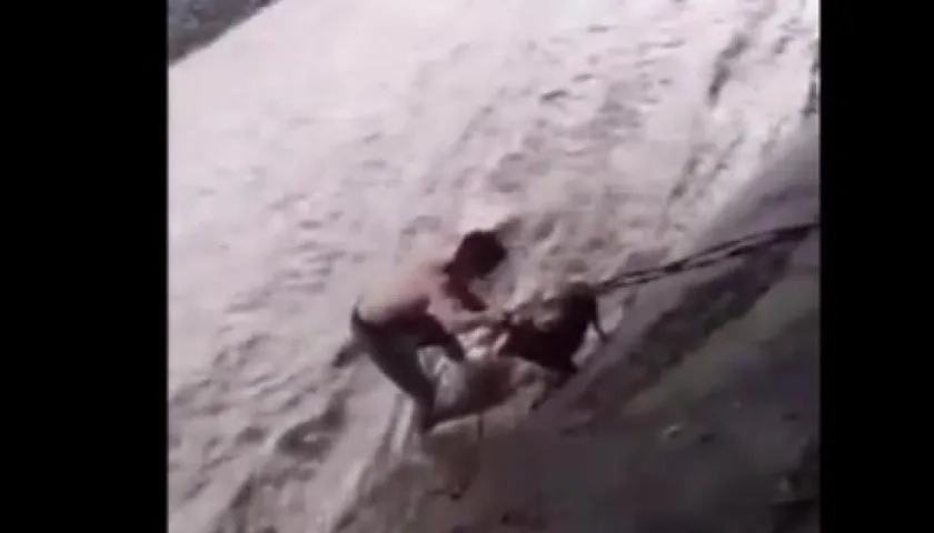 Félix Alvarado sujeta al perro con una cuerda.