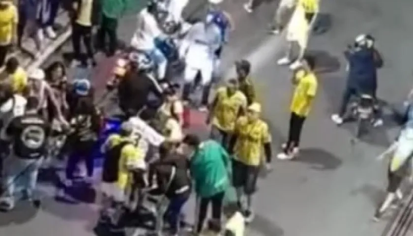 Varias personas auxilian al hincha del Atlético Bucaramanga herido a bala.