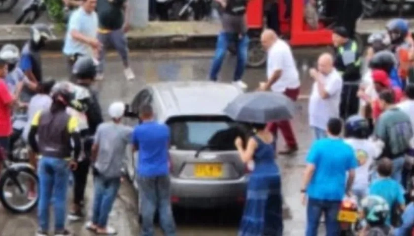 Curiosos rodean el vehículo en el que se desplazaba la mujer baleada.