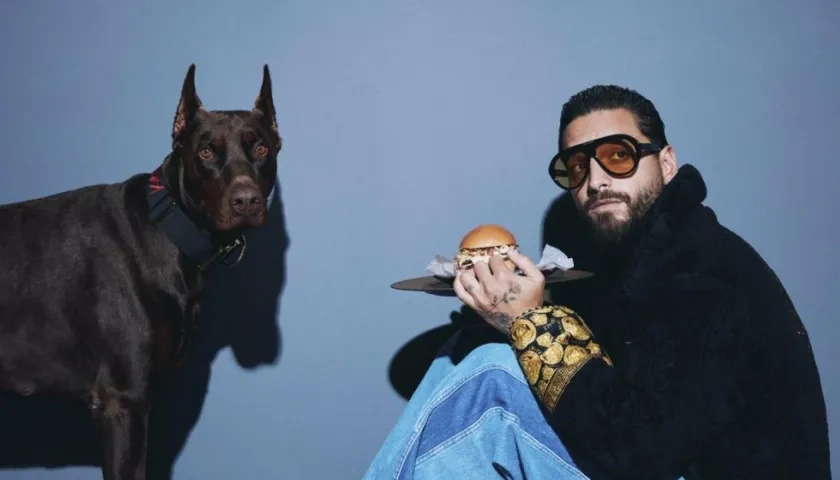 Maluma rodeado de hamburguesas y hot dogs (perros calientes).