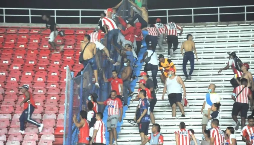 Hinchas invadiendo las tribunas vecinas para protagonizar el vandalismo.