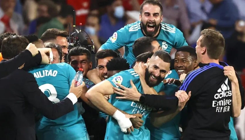 Karim Benzema felicitado por sus compañeros tras anotar ante el Sevilla.