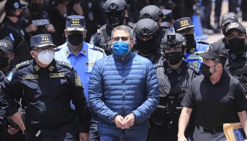 Policías custodian al expresidente hondureño Juan Orlando Hernández (c) rumbo a su extradición.