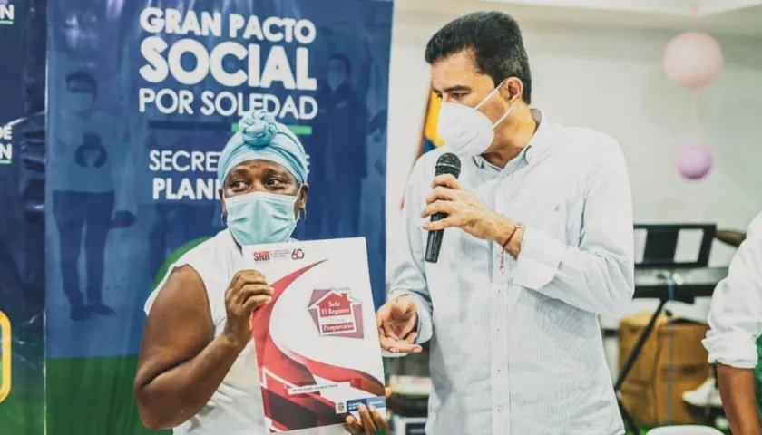 El alcalde Rodolfo Ucrós entregando un título de propiedad a una de las familias beneficiadas. 