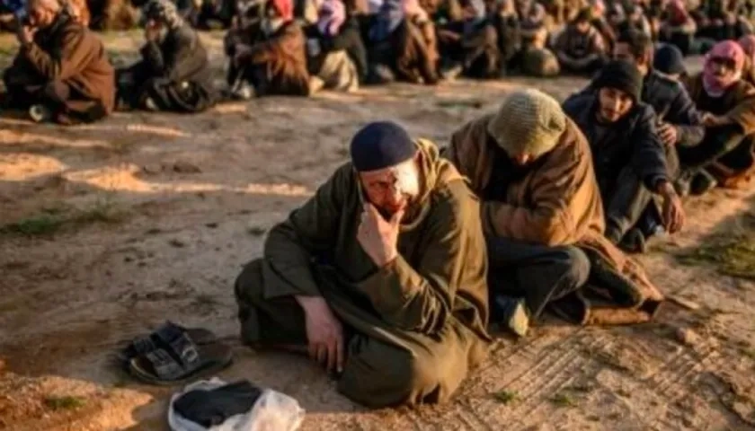 Foto captada en 2019 cuando hombres sospechosos de ser combatientes del Estado Islámico (EI) esperan a ser registrados por miembros de las Fuerzas Democráticas Sirias 