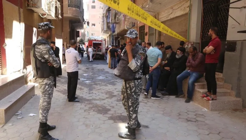 Personas y militares aguardan en las afueras de la iglesia que se incendió en El Cairo.