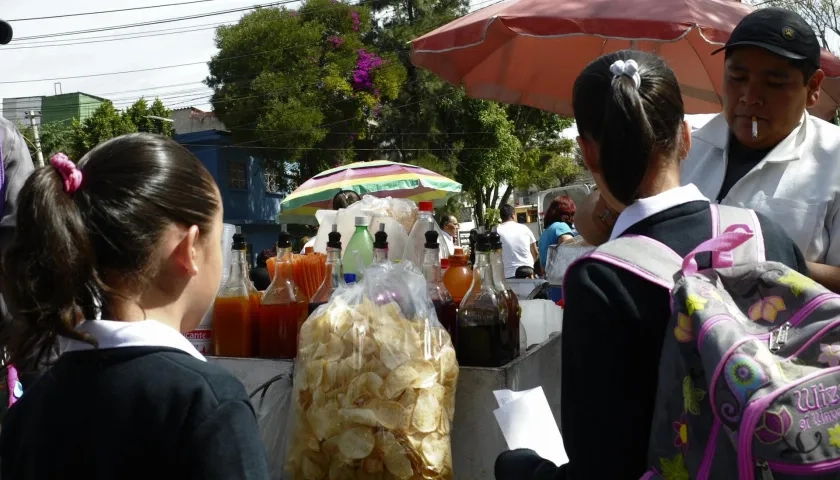 Unas niñas estudiantes compran frituras afuera de un colegio en Ciudad de México