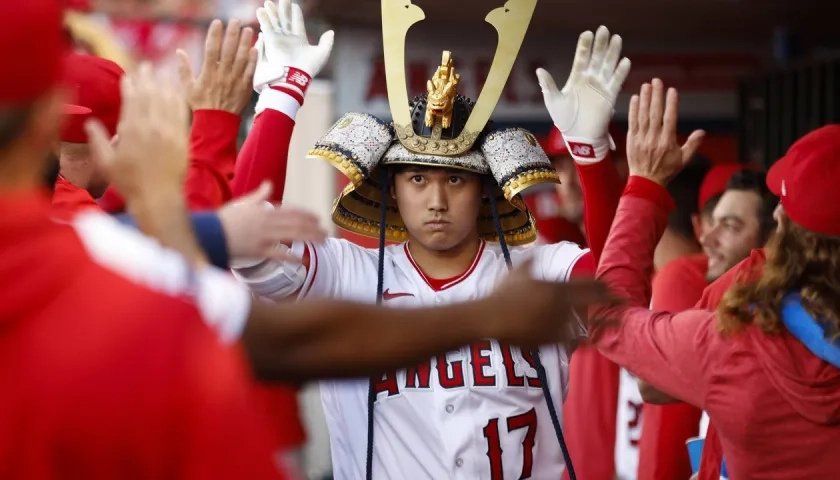 Shohei Ohtani es felicitado por sus compañeros en el dugout.