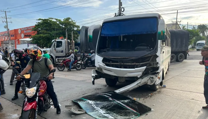 La moto tendida en el suelo y el bus implicados en el accidente.