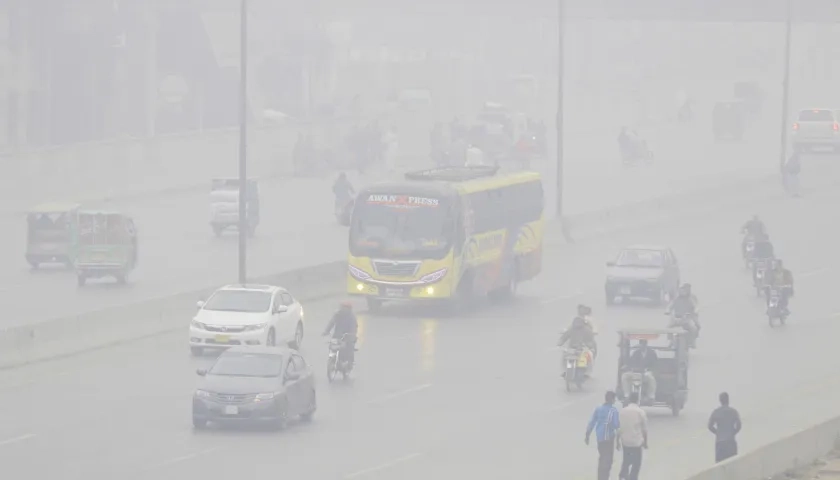 Personas viajan en automóviles y motocicletas bajo una nube de contaminación en Lahore (Pakistán)