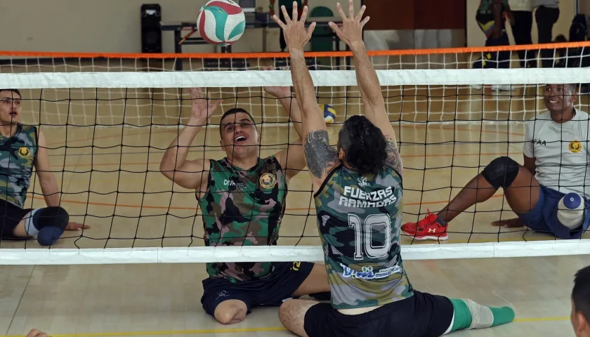 El veterano del Ejército Edward Guerrero (2-i) participa en una práctica de voleibol.