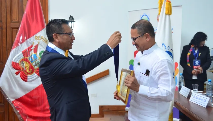 Jaime Fernández, secretario general de la Federación para la Paz Universal, le impone a Fausto Pérez la medalla.