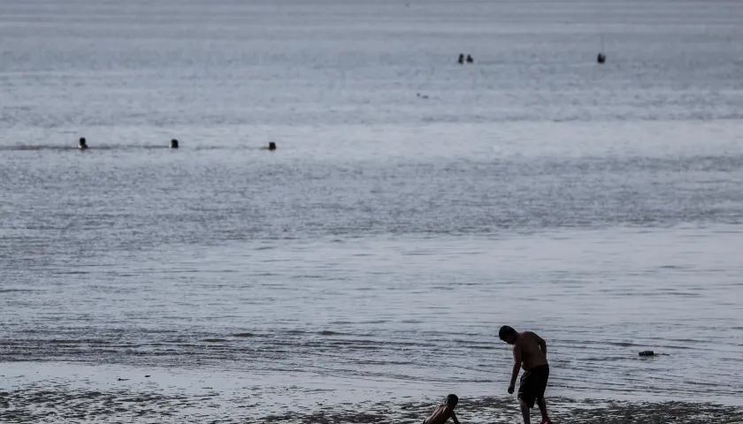 Un hombre y un niño se bañan en el Río de la Plata, en una fotografía de archivo