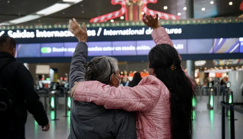 Dos mujeres despiden a familiares en el aeropuerto El Dorado de Bogotá