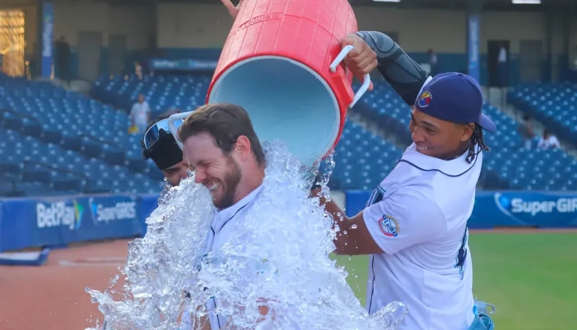 Luke Brown es bañado por su compañero de equipo Félix Reyes.