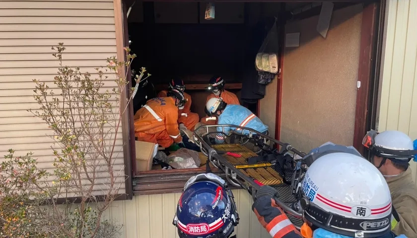 Rescatistas sacan a la anciana de la vivienda.