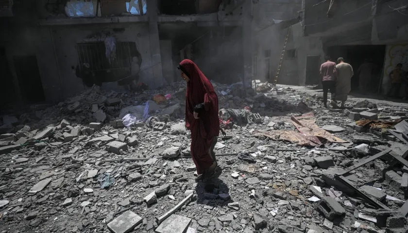 Palestinos inspeccionan los daños tras un ataque aéreo israelí en el campo de refugiados de Al Bureij, en el sur de la Franja de Gaza