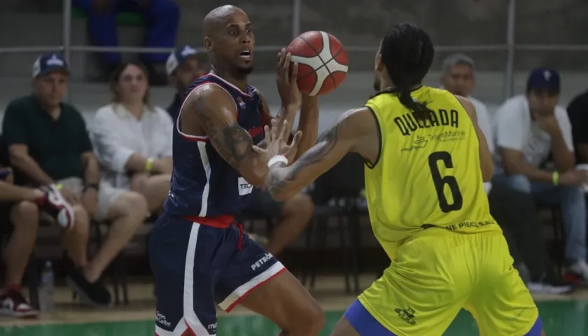 El panameño Ernesto Oglivie, de Titanes, en poder de la.pelota con la marca de Jean Carlos Quezada. 