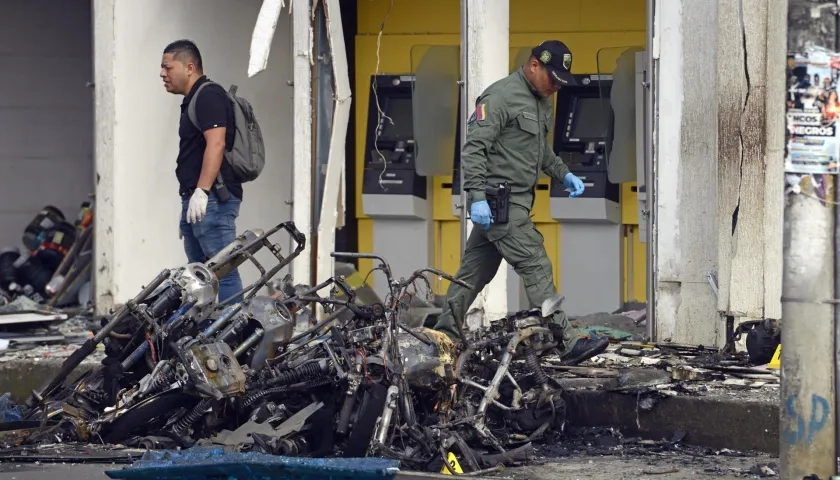 Uniformados caminan sobre los destrozos tras el atentado con motocicleta bomba en una estación de Policía en Jamundí