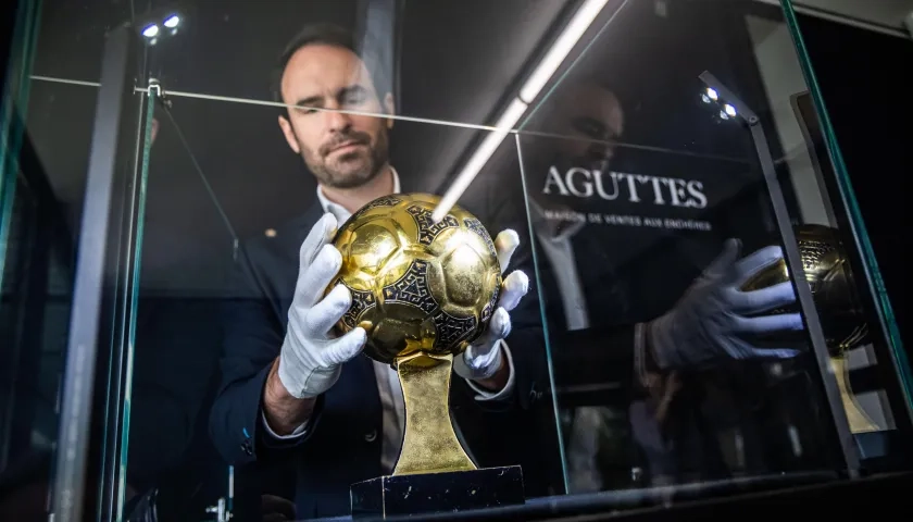 Francois Thierry, de la casa de subastas Aguttes, con el Balón de Oro de Maradona. 