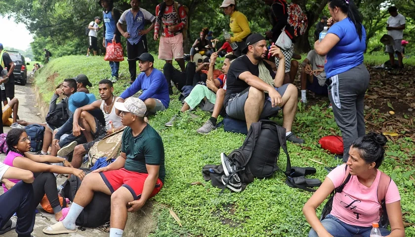 Migrantes descansan a un costado de la vía, en el municipio de Huixtla en Chiapas (México).